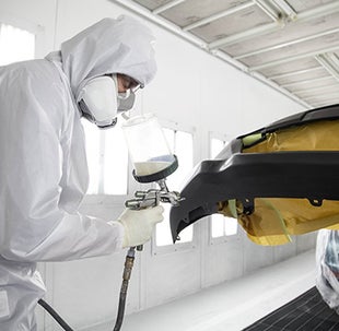 Collision Center Technician Painting a Vehicle | DARCARS Toyota of Silver Spring in Silver Spring MD
