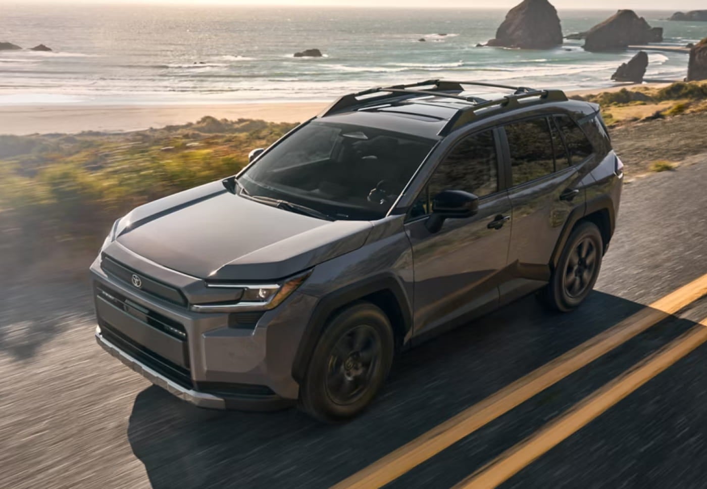 Toyota RAV4 driving along a coastal road.